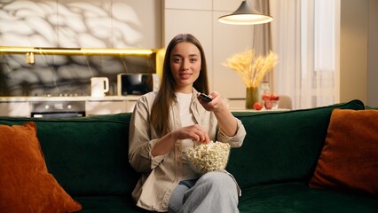 Relaxing holiday weekend at home living room female girl relax eating popcorn woman watching TV...