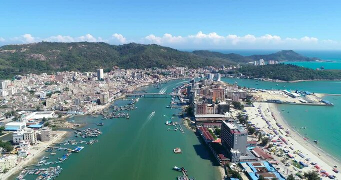 Huizhou bimonthly bay harbor and coastline during the day showing boats, buildings, the cityscape, and the mountainous topography