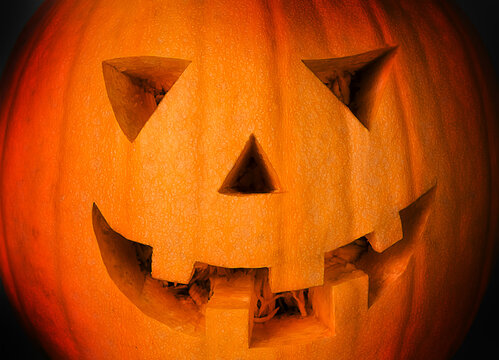 Spooky pumpkin with carved grimace. Jack lantern in the dark.