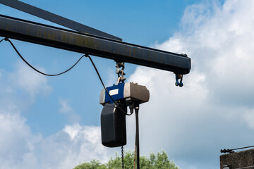 Crane lifting equipment against a cloudy sky