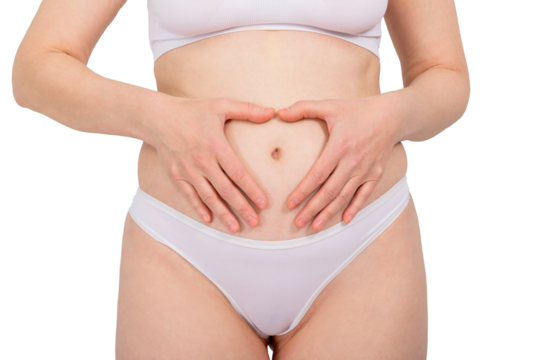 Woman making heart shape on her belly with her hands. Healthy digestion and gynecological health concept. Self-care and body awareness.