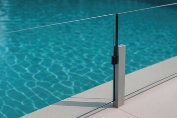 Detailed shot of a clear glass barrier separating sections of a swimming pool