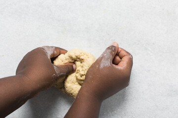 Overhead view of doughnut dough being kneaded on a white countertop, top view of doughnut dough on a white countertop