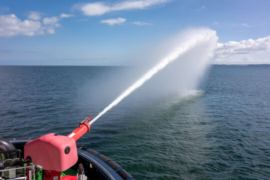 Fototapeta Firefighting Water Cannon Spraying Over Open Sea from Vessel. Maritime Safety, Emergency Response, and Marine Equipment Demonstration