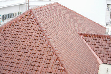 Top view of red clay roof tiles on a pitched residential roof, common in tropical architecture.