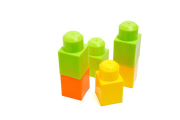 Group of green, yellow, and orange plastic blocks for educational toy play, isolated on white background.