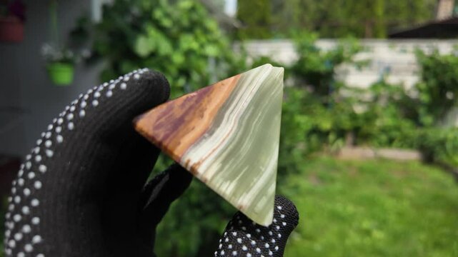 Middle-aged woman with green orgone stone pyramid. triangular stone pyramid. pyramid on the palm. stone symbol. magic item. Man showing a green orgone pyramid, close up