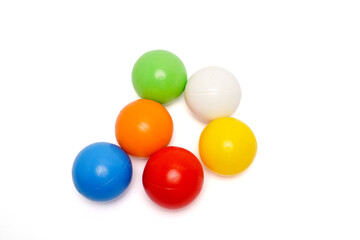 Top view of six colorful plastic balls arranged in a circle on a clean white background