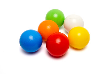 Top view of six colorful plastic balls arranged in a circle on a clean white background