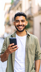 Confident man holding smartphone and looking at camera outdoors – modern lifestyle and mobile technology concept

