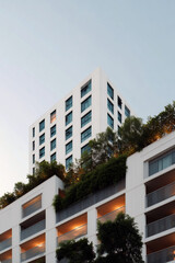 Obraz premium Modern high-rise building with lush green vertical garden facade, sustainable urban architecture 