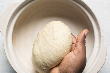 Overhead view of proofed bagel dough, Checking if dough is proofed using a finger poke test,...