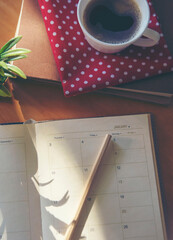 Calendar book for Planner to plan reminder daily appointment timetable, appointment, organization, and meeting agenda of job on wooden desk, work from home-vertical image.