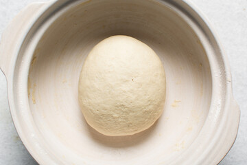 Overhead view of proofed bagel dough, Checking if dough is proofed using a finger poke test, process of making bagels