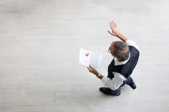 Top view speaking training in seminar : Senior caucasian business man leader in seminar, speaking on business training with group of diverse people company employees in meeting room