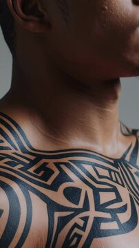 Polynesian male displaying intricate tribal tattoo while rotating upper body, showcasing cultural body art