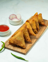 Closeup samosa with white and wooden board on bankground.
