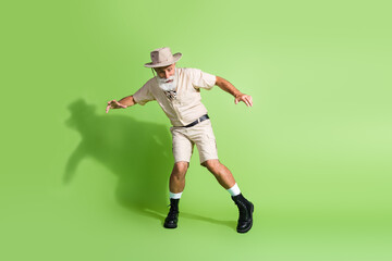 Photo of traveler old man moving careful step on trekking hiking route road isolated green color background