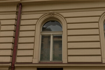 This image shows a closeup of an elegantly arched window on a historic building, featuring intricate decorations and striking lines that emphasize its architectural significance
