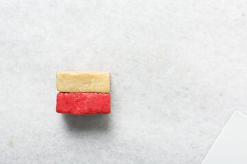 Overhead view of a battenburg cookie, top view of checkerboard cookies, Vanilla and strawberry sugar cookies on a parchment lined baking sheet