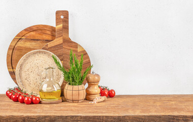 A rustic kitchen counter displays tomatoes, herbs, olive oil, and wooden tools, creating a warm and...