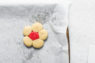Overhead view of Vanilla and strawberry pink sugar cookie dough on a parchment lined baking sheet,...