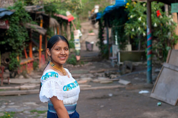 Guatemalan woman wearing traditional clothes smiling in a rural village