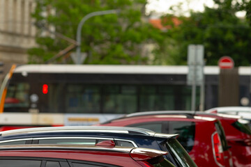 This urban view showcases a scene busy with parked cars alongside a bus in the background,...
