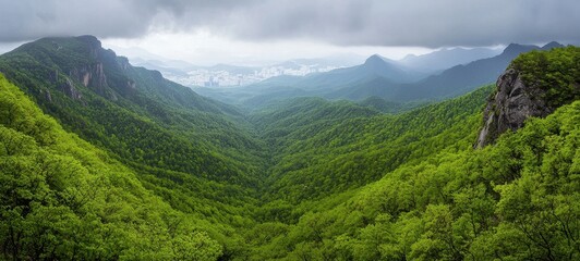 Fototapeta premium Lush Green Valley Surrounded by Mountains Under Cloudy Skies