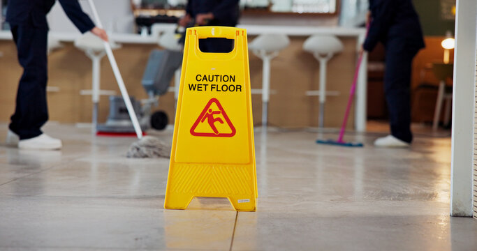Cleaning, warning and caution for wet floor, sign and people with equipment for disinfection or mop. Board, info and team with tools for sanitation of coffee shop, routine and service in business - Powered by Adobe
