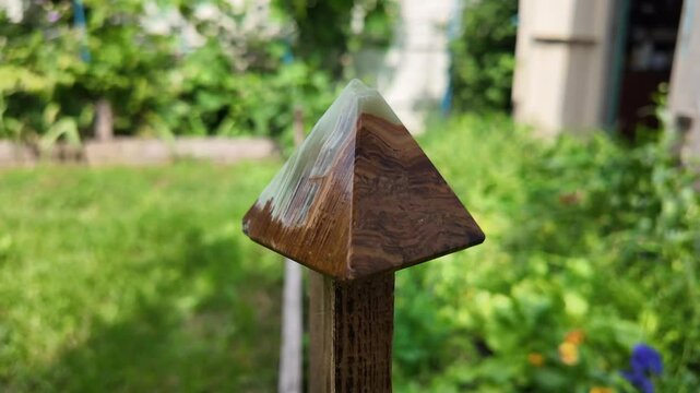 Middle-aged woman with green orgone stone pyramid. triangular stone pyramid. pyramid on the palm. stone symbol. magic item. Man showing a green orgone pyramid, close up