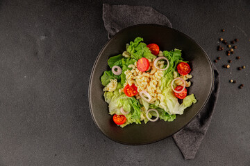 Pasta salad green leaf lettuce, tomato, pasta, onion fresh delicious gourmet food background on the table rustic food top view copy space keto and paleo diet vegan and vegetarian food
