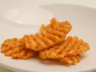 Waffle fries piled on white plate