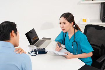 Asian medical doctor talking with male patient about shoulder pain in hospital. Physiotherapy, neck...