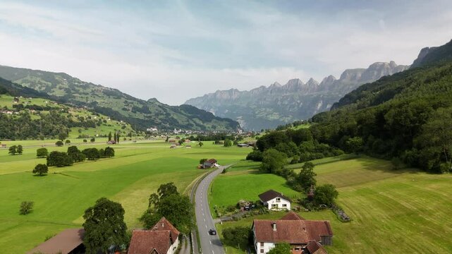 Scenic aerial view of rural countryside and Alpine mountain landscape near Flums, Berschis and Walenstadt, in the canton of St. Gallen, Switzerland &ndash; drone footage