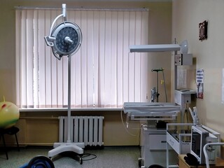 in the maternity hospital, a shadowless lamp by the window, tables for neonatal resuscitation and...