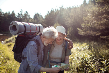 Senior couple hiking in nature with a map
