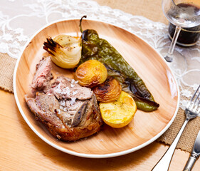 There are fried lamb ribs on plate. Meat appetizer is complemented with baked potatoes and bell...