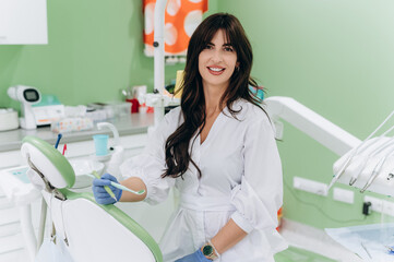 Portrait of a young female dentist in uniform at a modern dental clinic, smiling confidently
