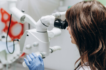 Portrait of a young female dentist working behind modern dental equipment in a clinic.