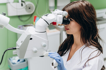 Portrait of a young female dentist working behind modern dental equipment in a clinic.