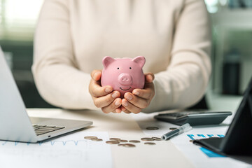 Female hand holding pink piggy bank, investment concept of saving money, saving money, planning and...