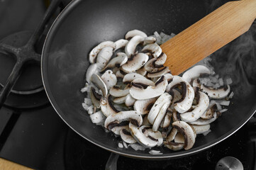 Fry mushrooms in a pan in the kitchen
