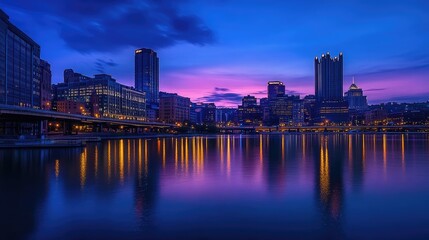 Fototapeta premium Vibrant Night Cityscape of Pittsburgh with Colorful Reflections in Water Under Dramatic Twilight Sky