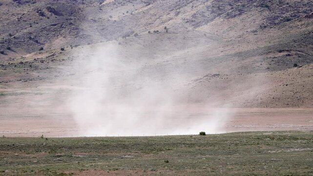 Large dust devil blowing across the Utah desert in slow motion.