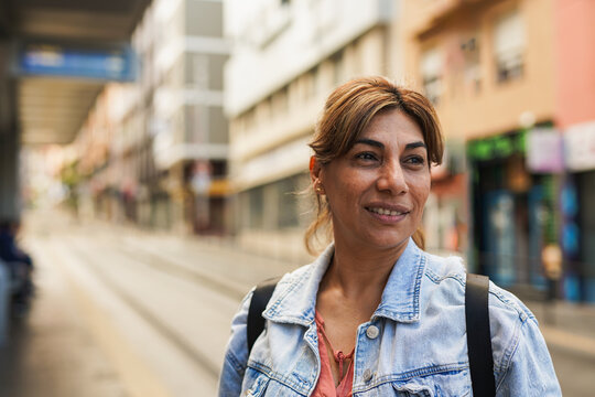 Mature latin woman waiting at tram station in the city - Travel and urban lifestyle concept - Powered by Adobe
