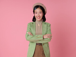 Portrait confidence young Asian business woman smiling and arms crossed isolated on pink background.