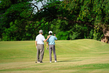 Senior man mentoring a young golfer on a sunny day at a lush golf course. Concept of guidance, coaching, and bonding through sport in a peaceful outdoor setting.