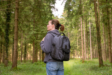 Fototapeta premium woman walking in a forest and enjoying nature, with backpack