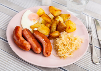 Fried Spanish sausages with egg, golden potatoes and cabbage. Delicious lunch with vegetables and...